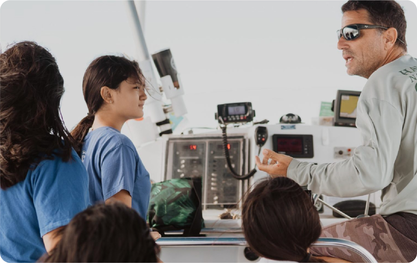 Captain teaching kids about ocean navigation on Hawaii Ocean Rafting boat