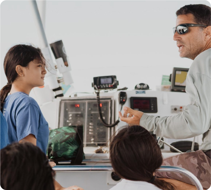 Captain teaching kids about ocean navigation on Hawaii Ocean Rafting boat